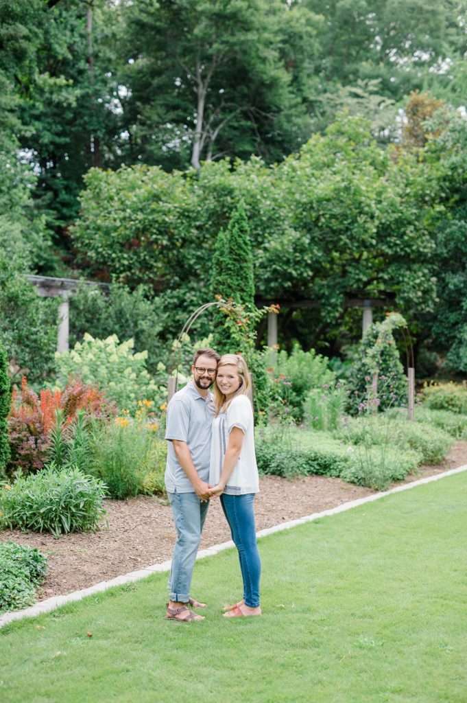 engaged couple smiling in garden