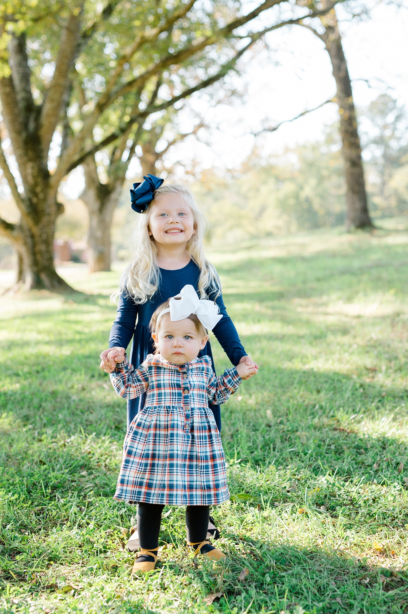 west georgia family photographer family session at sweet meadows farm sisters holding hands
