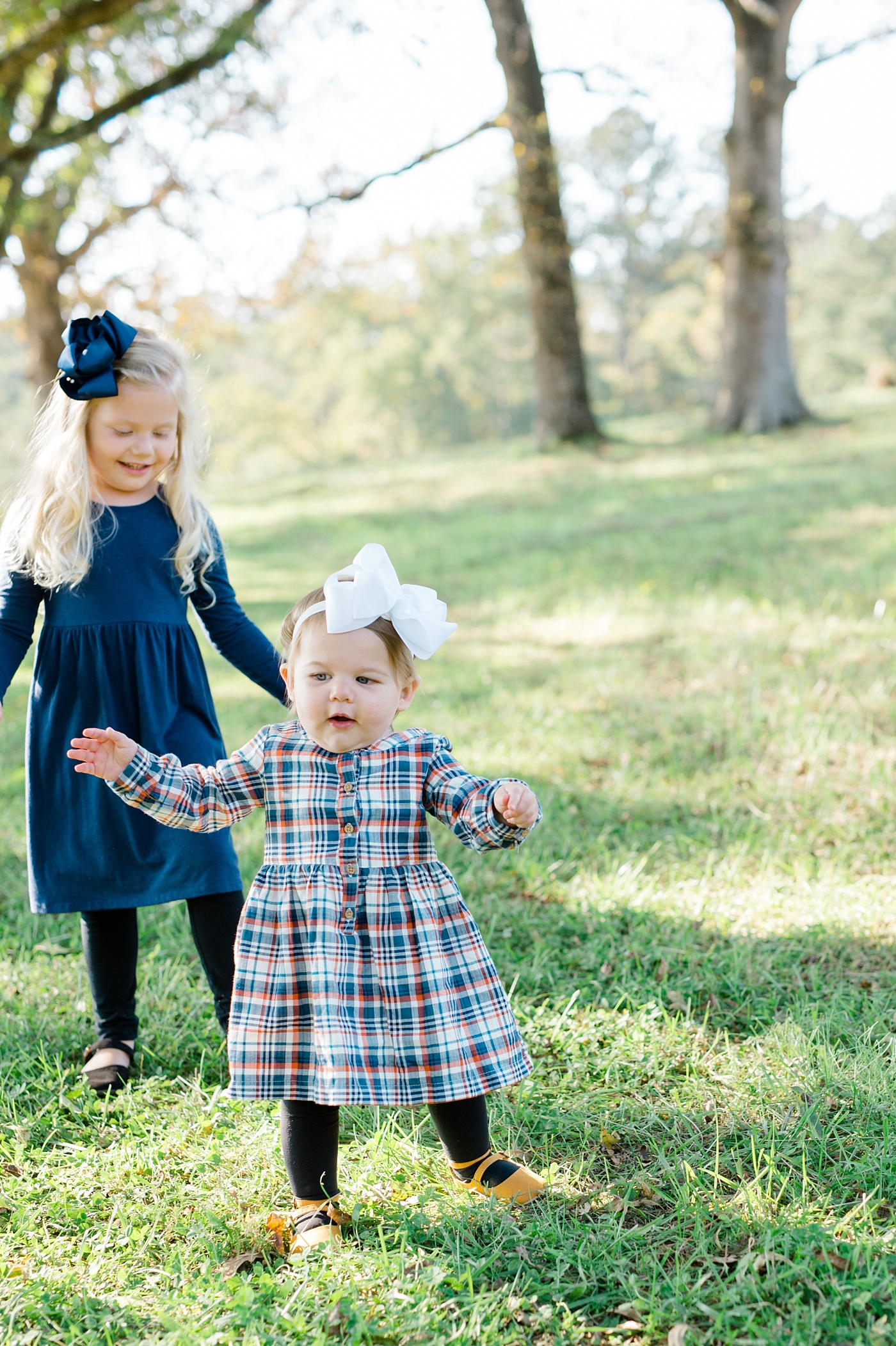 west georgia family photographer family session at sweet meadows farm sisters walking together